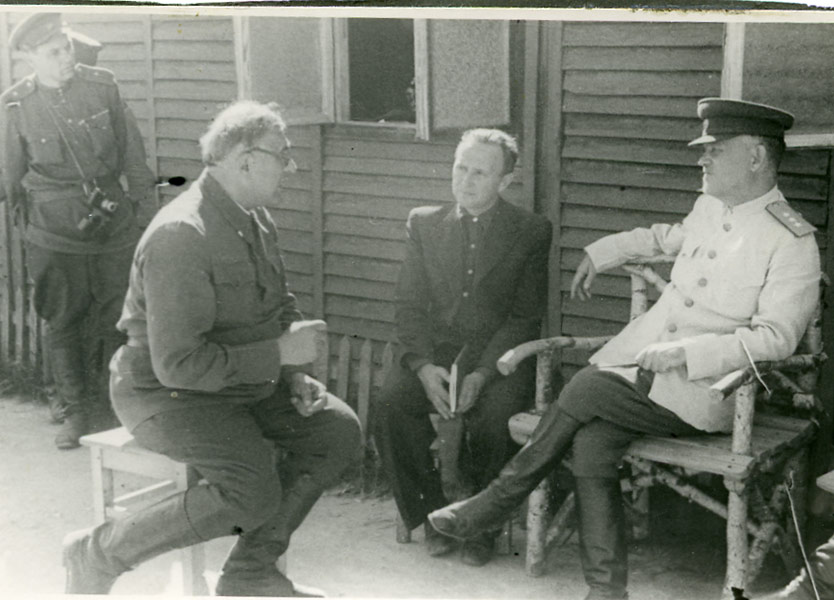 Н.А. Булганин и Д.И. Кудрявцев слушают советского военнопленного — врача — заключенного концлагеря «Майданек». Польша, август 1944 г.